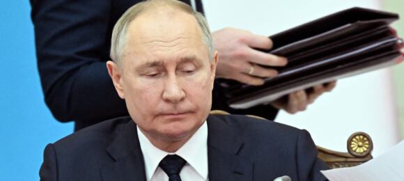 Władymir Putin, w tle człowiek z teczką