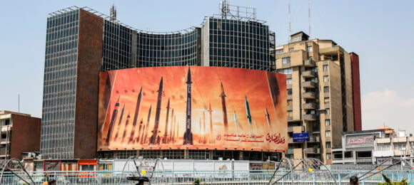 Ogromny propagandowy plakat przedstawiający rakiety rozwieszony na budynku w Teheranie