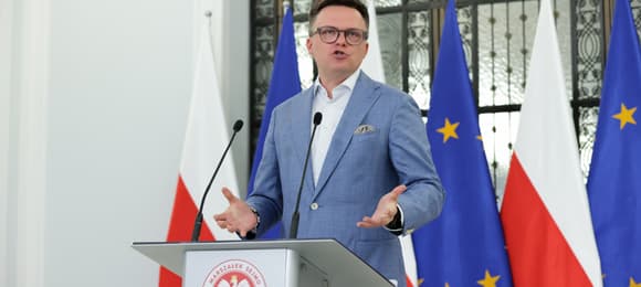 Marszalek Sejmu Szymon Holownia w błękitnej marynarce bez krawata przemawia podczas konferencji prasowej