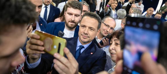 Tłum ludzi, w środku mężczyzna robiący sobie selfi z uiczestnikami wiecu