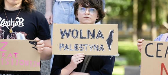 Młoda osoba trzymająca plakat z napisem „Wolna Palestyna