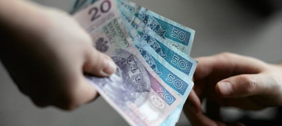 Dłoń wręczająca banknoty