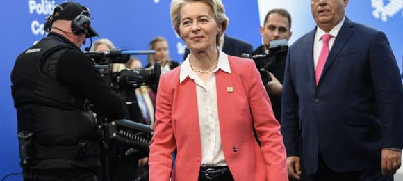 ursula von der leyen i stojący za nią voktor orban w korytarzu podczas szczytu ue