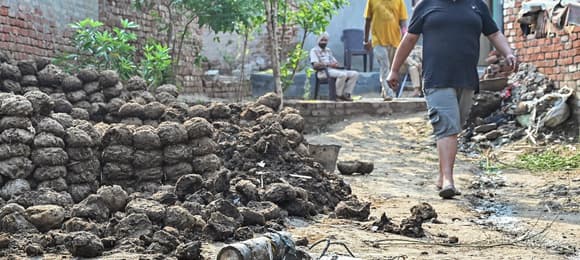 Residents walk past explosives, carried by a drone, after it was intercepted by the Indian air defence system, on the outskirts of Amritsar, on May 10, 2025. The Indian army on May 10 reported fresh Pakistani attacks along the border with its arch-foe as the conflict between the nuclear-armed neighbours spiralled. (Photo by Narinder NANU / AFP)