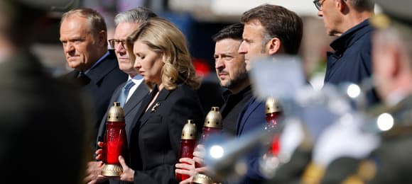 Pięciu mężczyzn i jednak kobieta stoi przed pomnikiem poległych w Kijowie