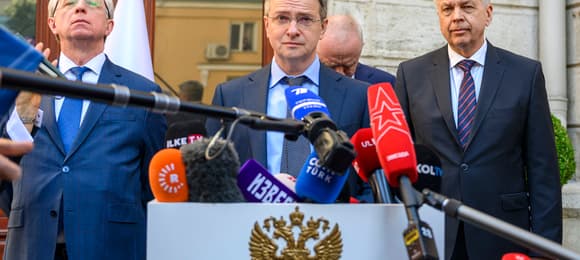 Na zdjęciu są cztery osoby. Są to mężczyzni w garniturach