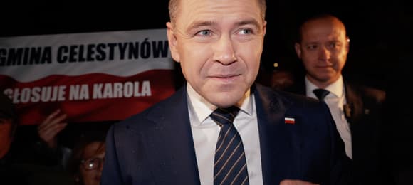 Karol Nawrocki pod parasolem podczas jednego z kampanijnych wieców.