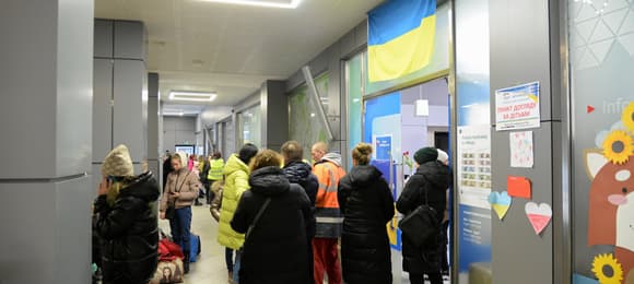 na zdjęciu widać kolejkę, w której stoi kilka kobiet. Są w kurtkach zimowych.