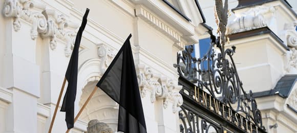 Żałobne czarne flagi na bramie Uniwersytetu Warszawskiego