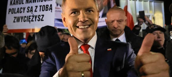 Karol Nawrocki uśmiecha się i pokazuje dwa kciuki w górę