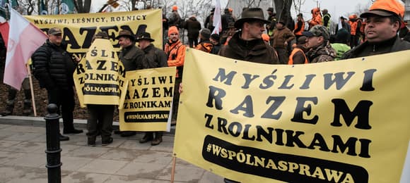 myśliwi protestują z żołtymi banerami z napisem
