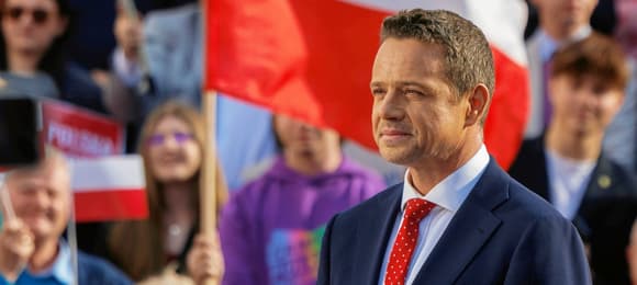 Rafał Trzaskowski na tle polskiej flagi