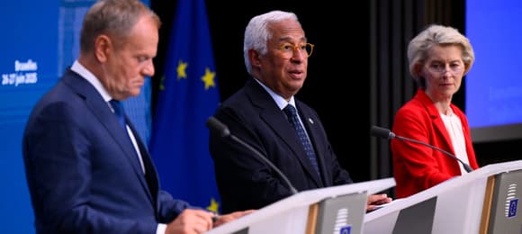 Troje przywódców stoi za pulpitami, w tle flafa Unii Europejskiej