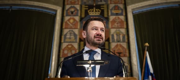 Mężczyzna z brodą stoi za mównicą