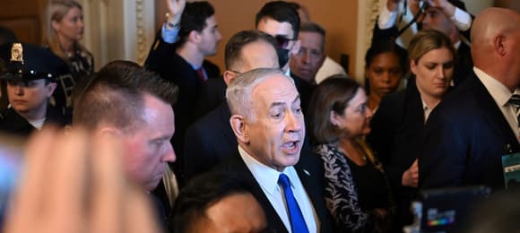 Premier Izraela Benjamin Netanjahu pośród ludzi w pomieszczeniu