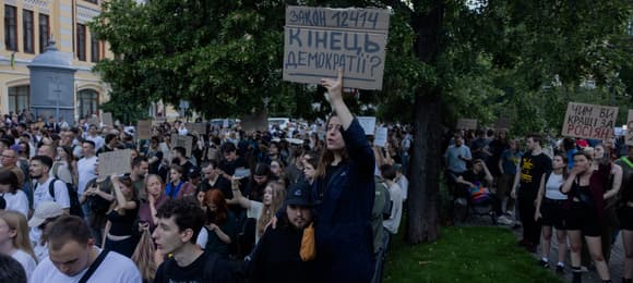 Protesters hold placards during a demonstration calling for the Ukrainian president to veto a law passed by parliament that reduces the powers of Ukraines National Anti-Corruption Bureau (NABU) and Specialised Anti-Corruption Prosecutor's Office (SAPO) in downtown Kyiv on July 22, 2025, amid the Russian invasion of Ukraine. Ukraine's parliament voted on July 22 to revoke the autonomy of the two anti-corruption agencies, a move that critics say will allow government meddling in high-profile graft cases. (Photo by Tetiana DZHAFAROVA / AFP)