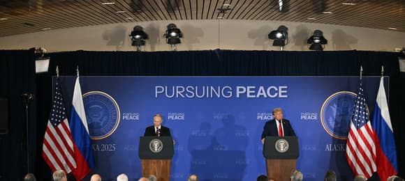 Dwaj mężczyźni w garniturach na konferencji prasowej.