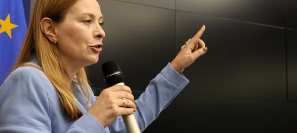 Katarzyna Pełczyńska-Nałęcz na tle unijnej niebieskiej flagi z gwiazdką
