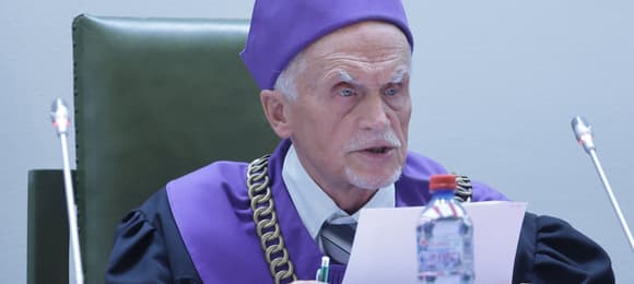 Stary mężczyzna w todze i fioletowym birecie sędziego Sądu Najwyższgo