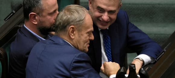 Od lewej: premier Donald Tusk, wicepremier, minister obrony narodowej Wladyslaw Kosiniak - Kamysz i wicepremier, minister cyfryzacji Krzysztof Gawkowski siedzą w ławie sejmowej i rozmawiają ze sobą