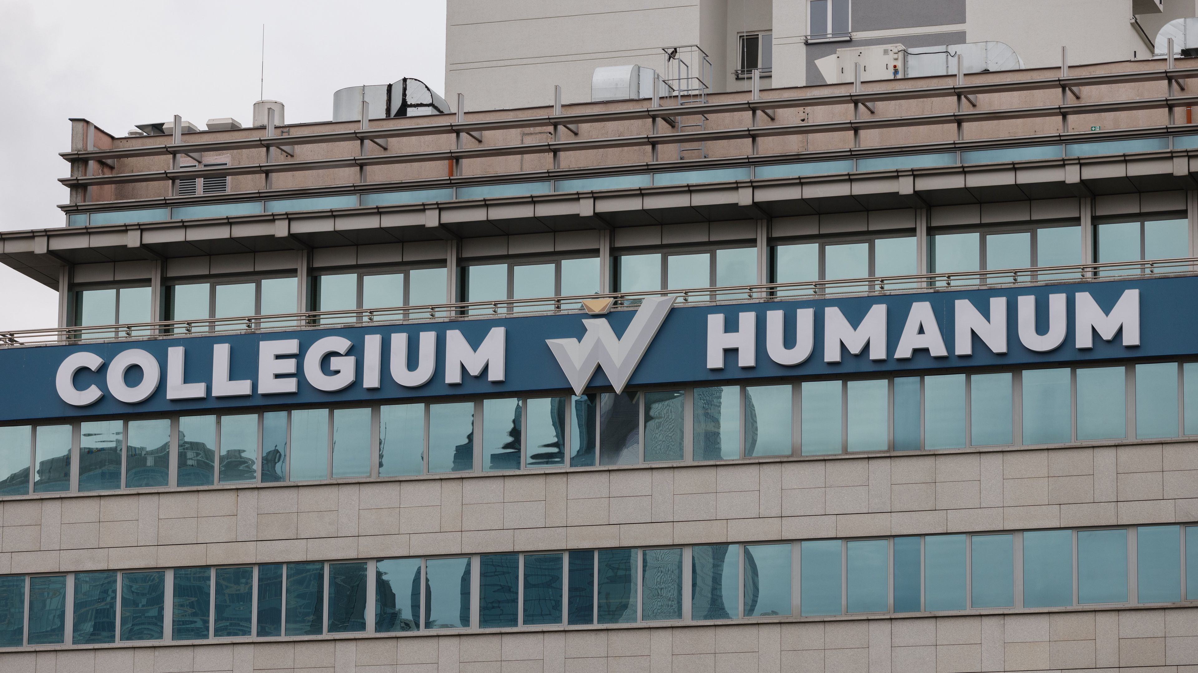 Napis "Collegium Humanum" na ostatnim piętrze przeszklonego biurowca