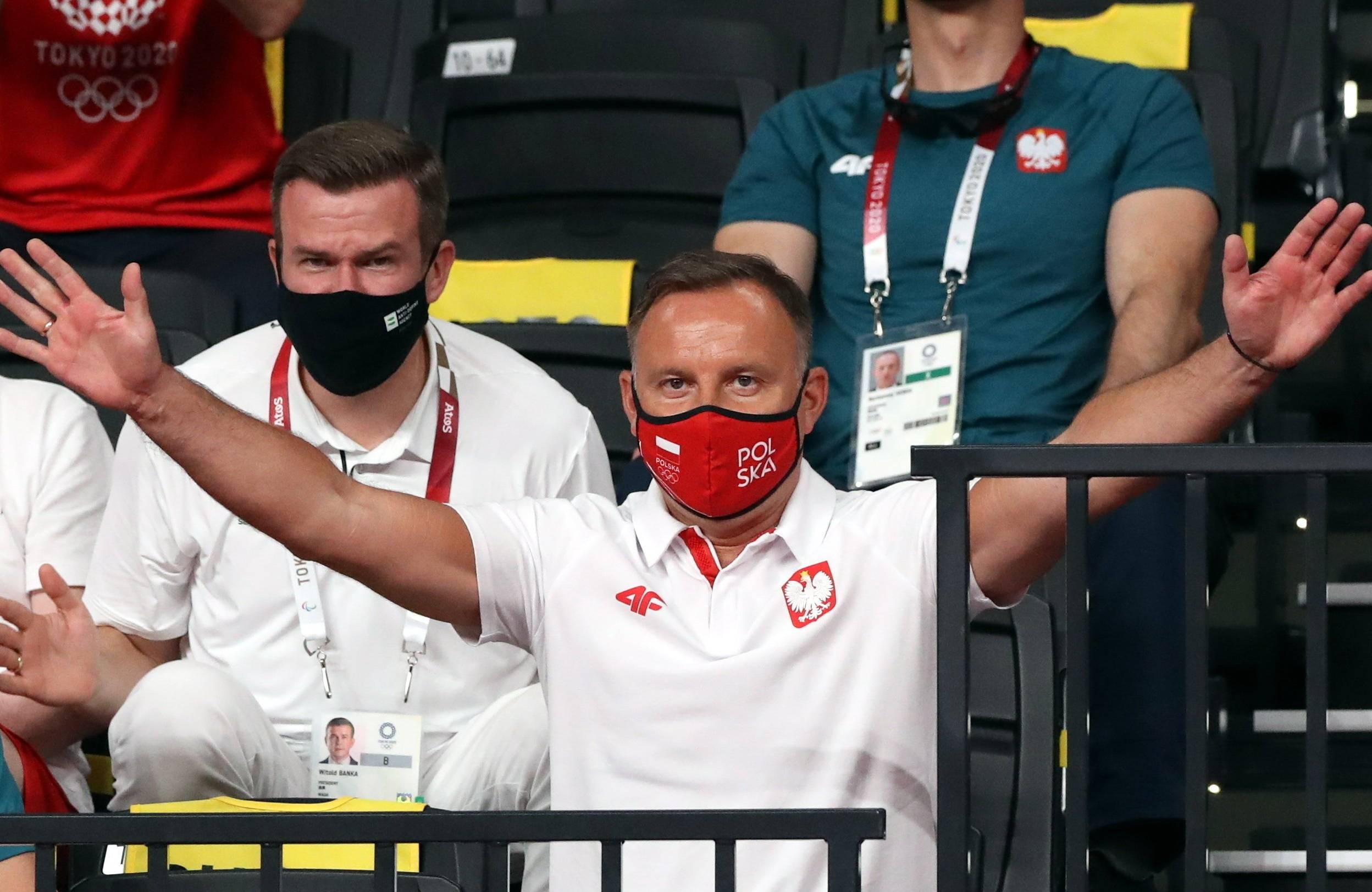 24.07.2021, Tokio. Mężczyzna w białej koszulce z godłem Polski na piersi i w czerwonej maseczce na twarzy z napisem "Polska" rozkłada szeroko ręce