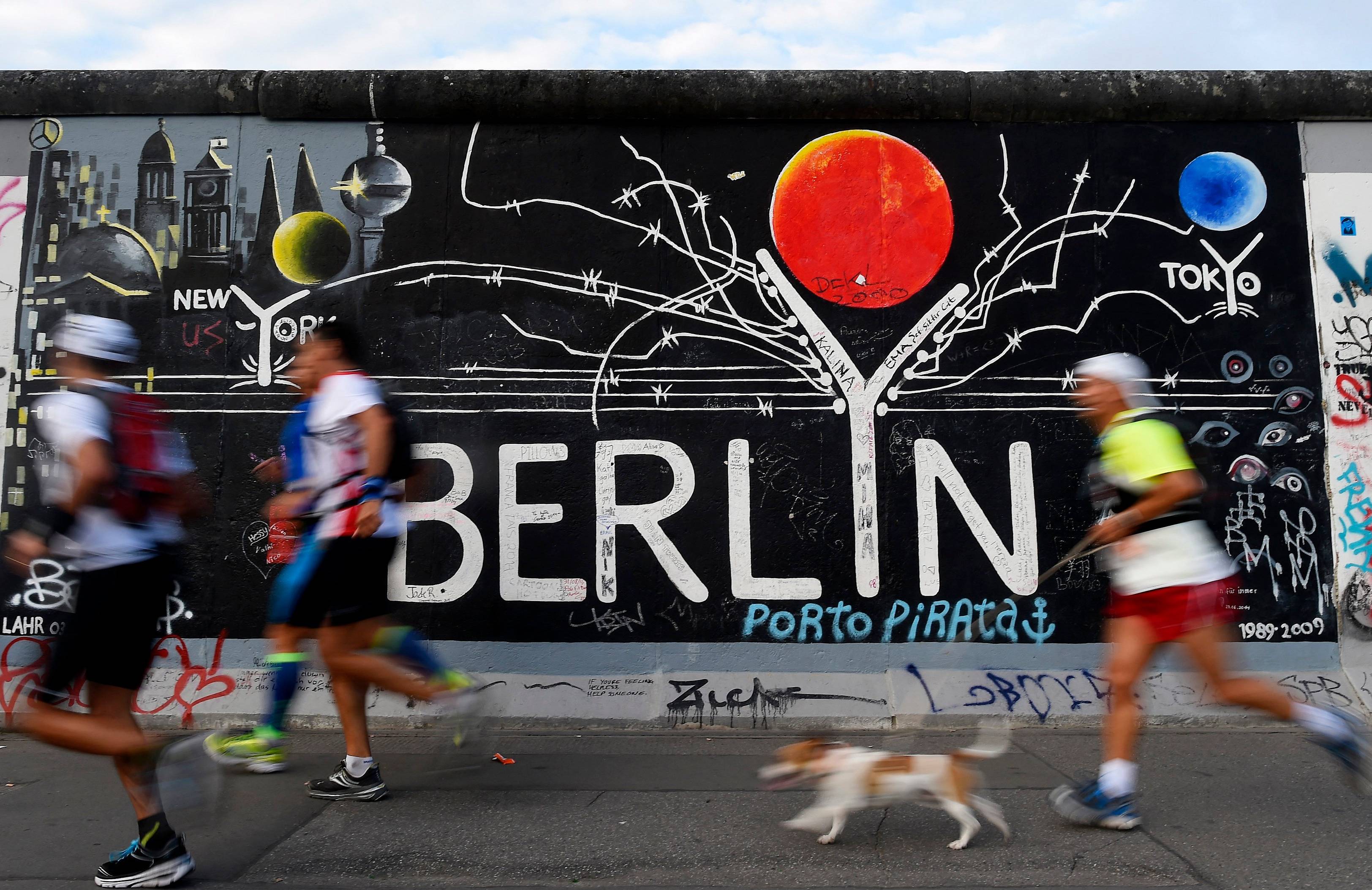 Biegacze mijają dawny mur berliński
