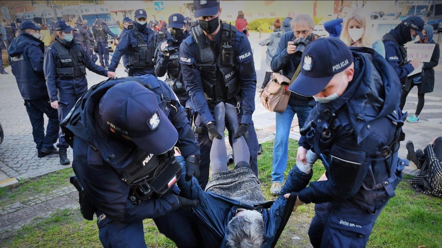 babcia Kasia niesiona przez czterech policjantów