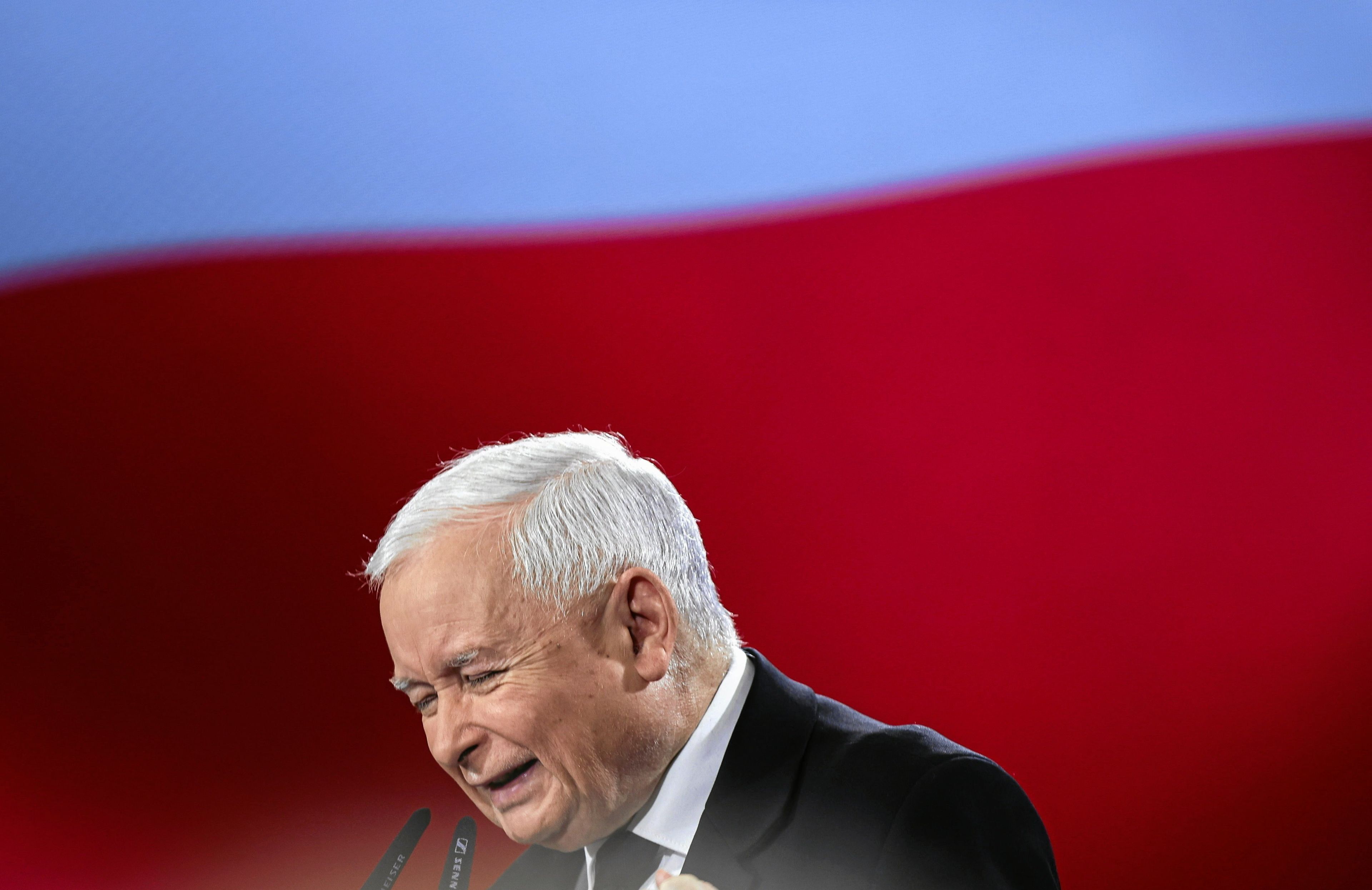 Siwy mężczyzna przemawia z zaciśniętymi pięściami