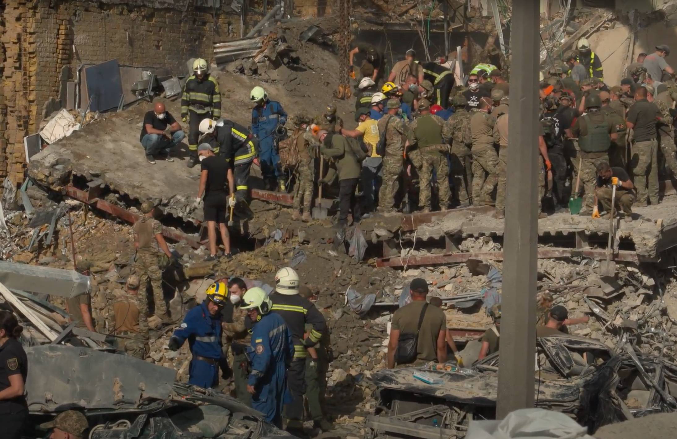 ratownicy i wolontariusze pracujący na gruzach zniszczonego budynku