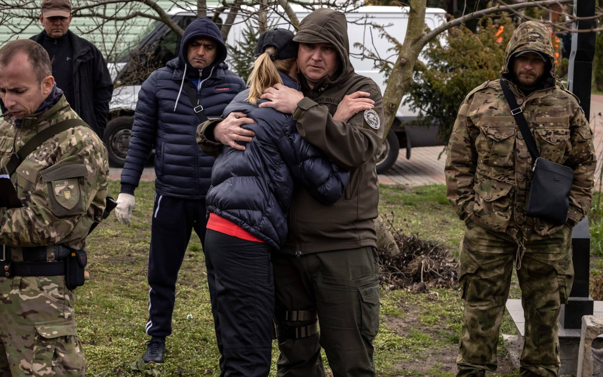 Relatives react past the exhumed body of Gostomel's mayor Yuriy Prylypko, who was buried near a church in Gostomel village, Kyiv region, on April 12, 2022. - Prylypko, 62, was killed on March 7 after Russian forces rolled into the Kyiv commuter town he managed. The municipal council said he was shot dead whilst "handing out bread to the hungry and medicine to the sick". (Photo by FADEL SENNA / AFP)