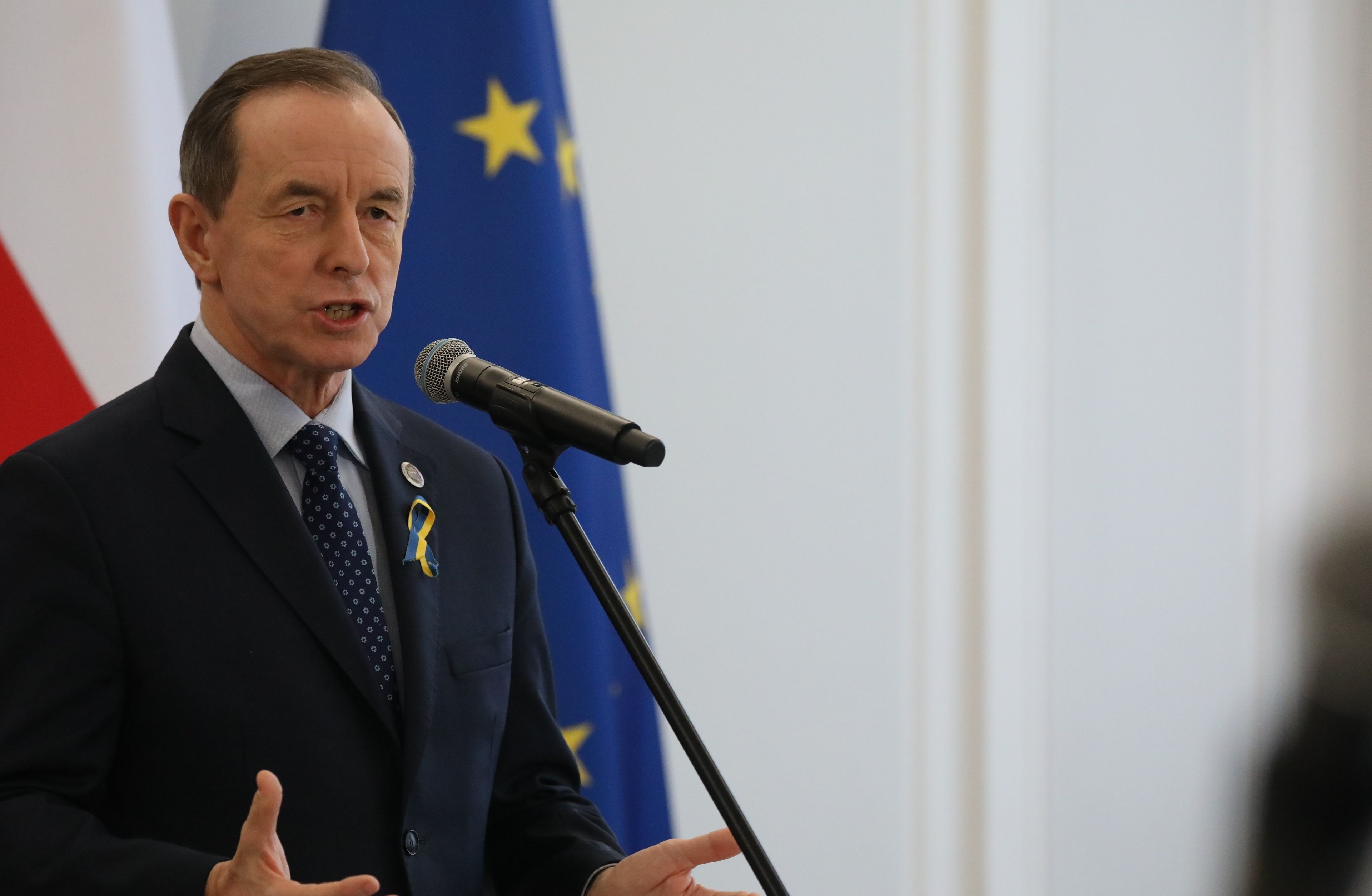 Męzczyzna, na tle flag Polski i UE, Tomasz Grodzki