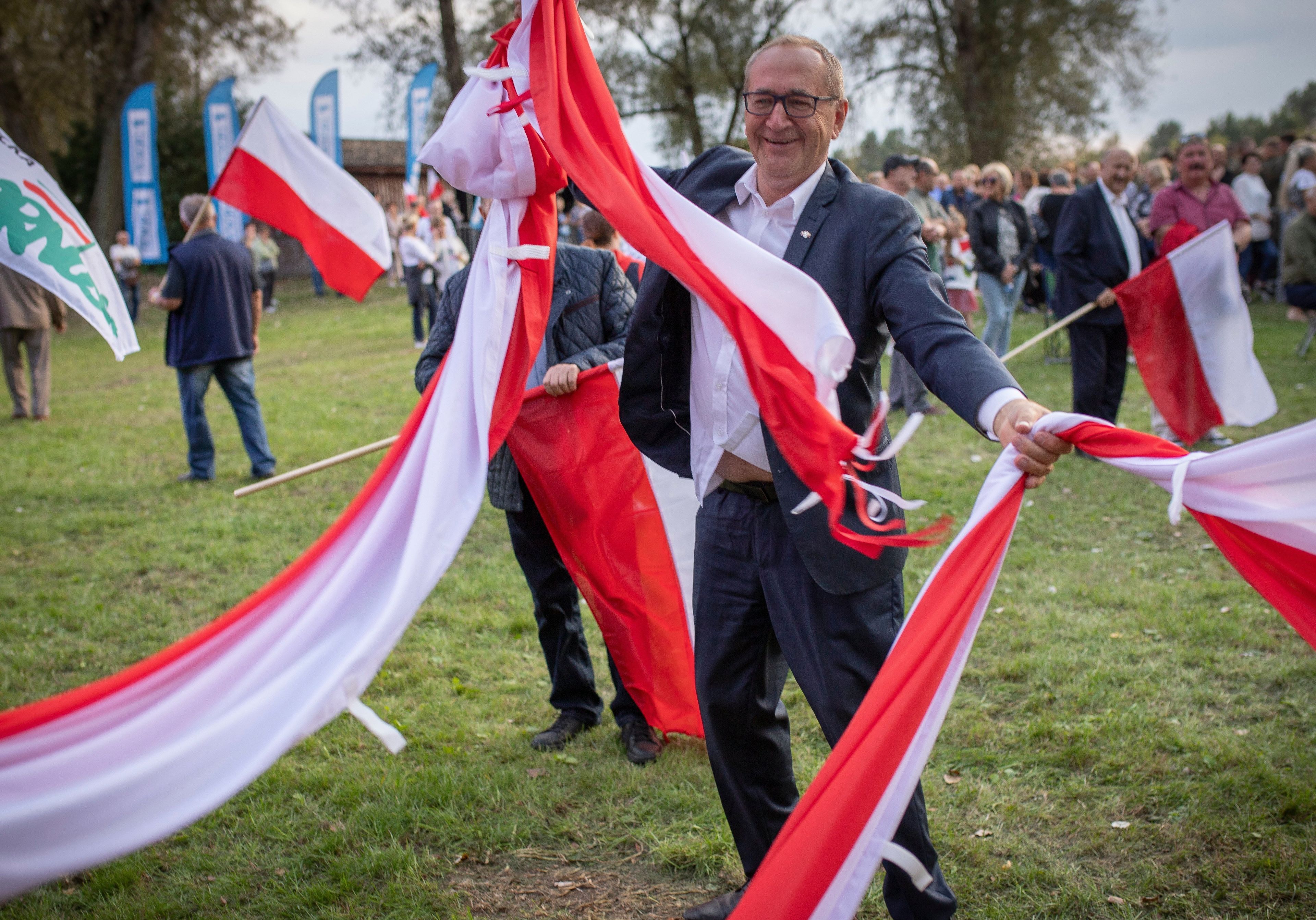 Poseł PiS powiewa białoczerwonymi szarfami