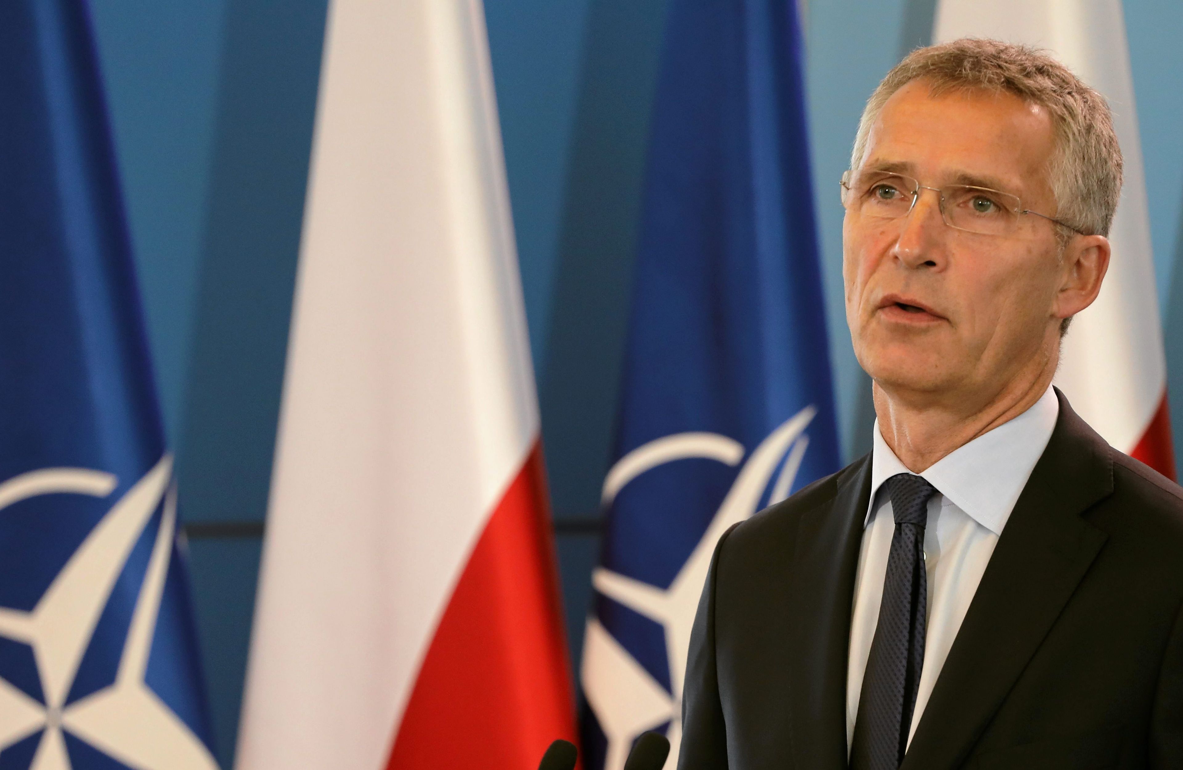 sekretarz generalny nato na tle flag nato i polski