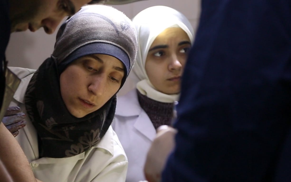Al Ghouta, Syria - Dr. Amani (center) and Dr Alaa (right) in the operating room. (National Geographic)
