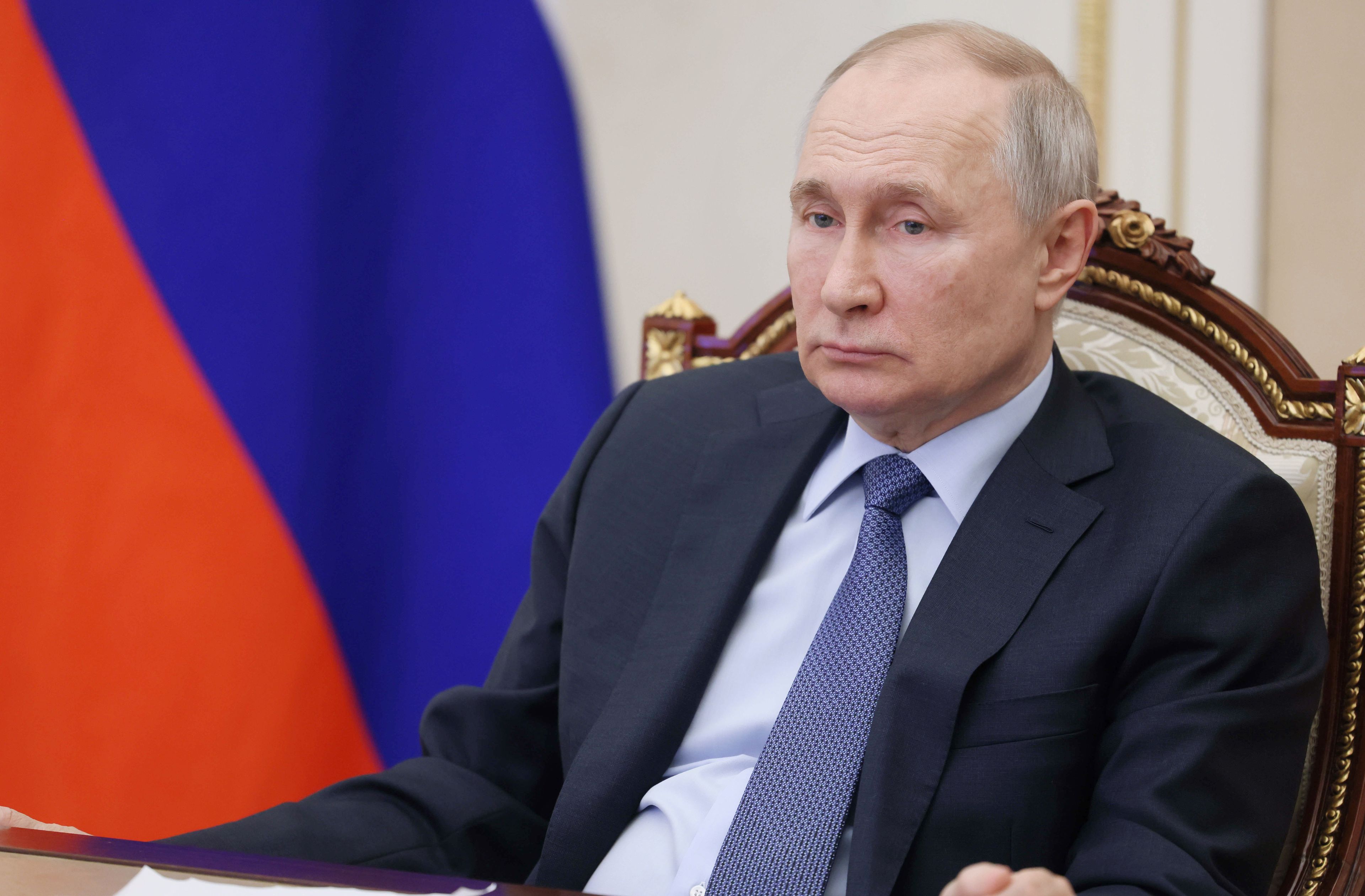 Starszy mężczyzna o pustym spojrzeniu siedzi przy stole. To Władimir Putin.
