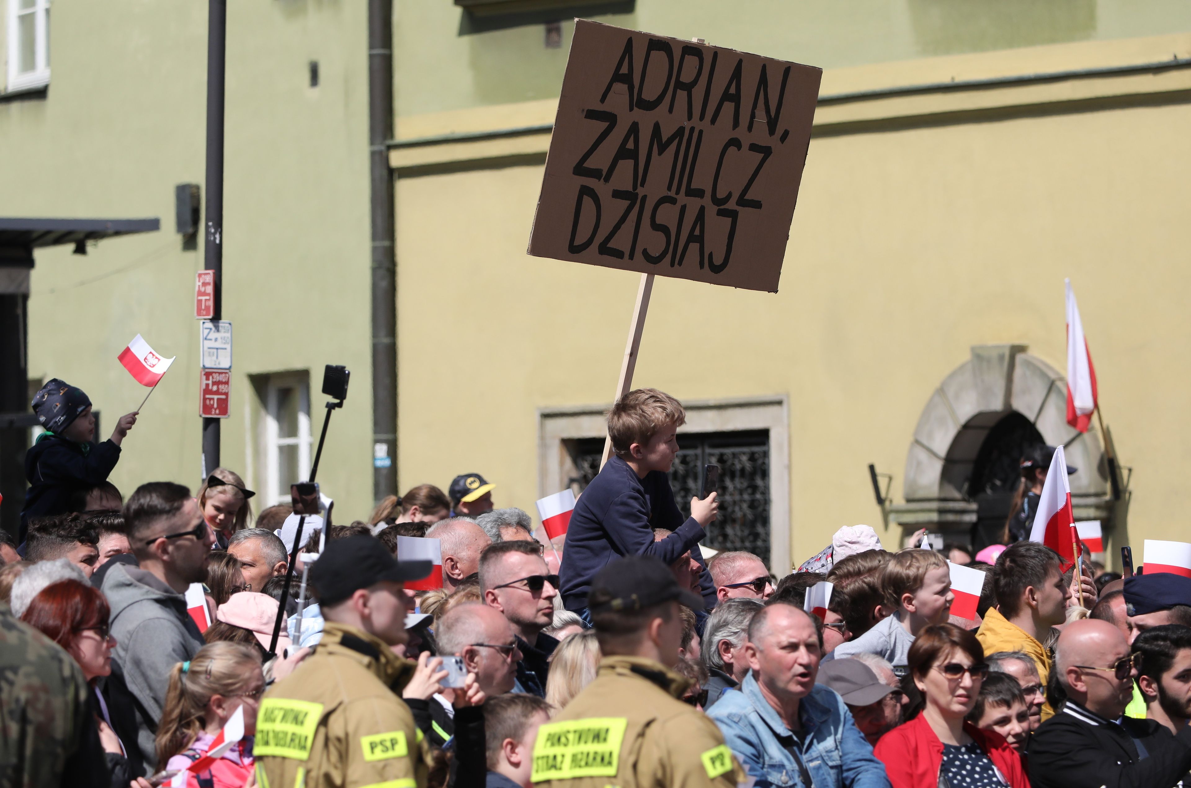 tłum ludzi z którego wystaje transparent o treści: Adrian zamilcz dzisiaj