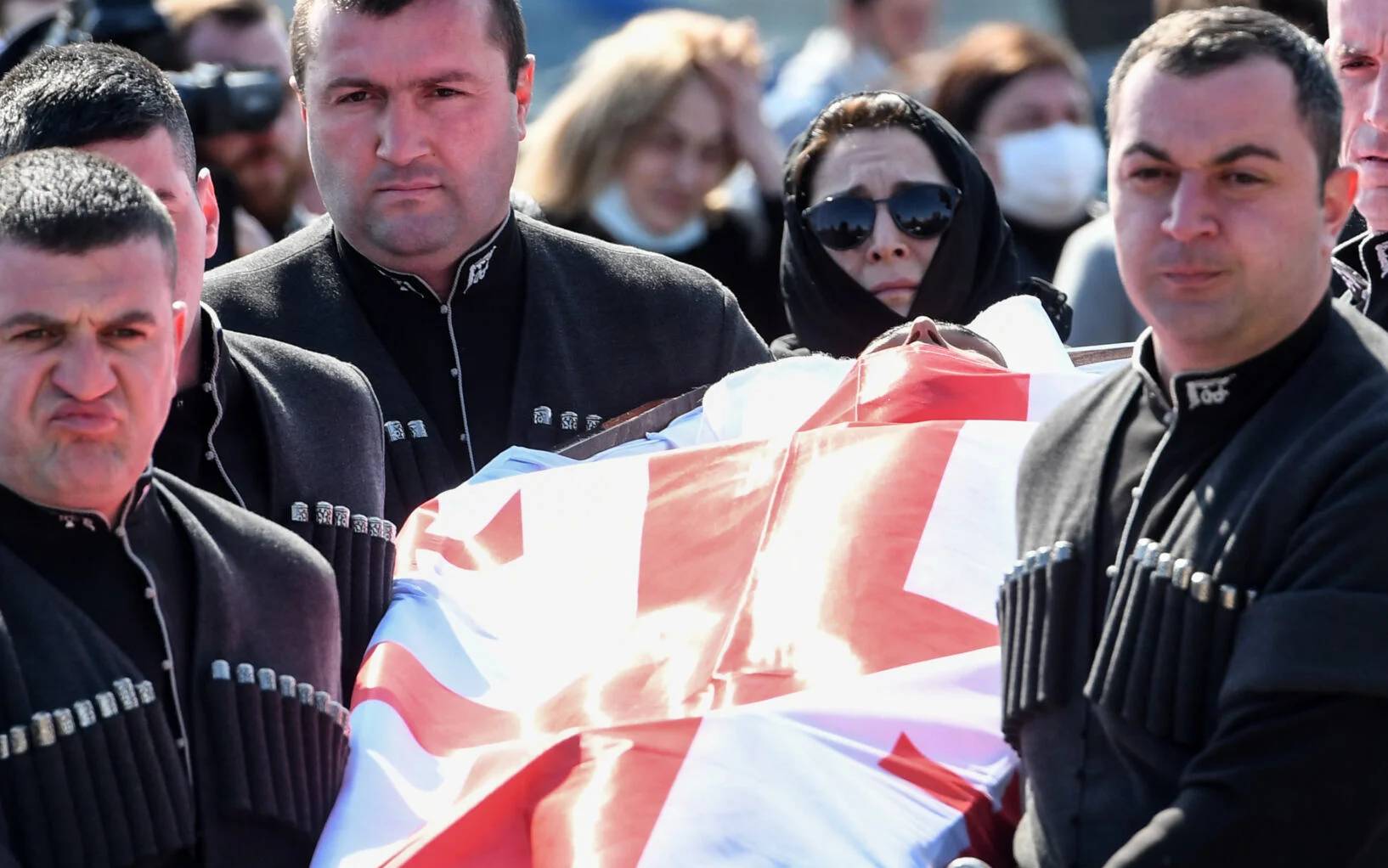 People attend a funeral of David Ratiani, a Georgian volunteer fighter killed during the ongoing Russian military action in Ukraine, in Tbilisi on March 26, 2022. (Photo by Vano SHLAMOV / AFP)