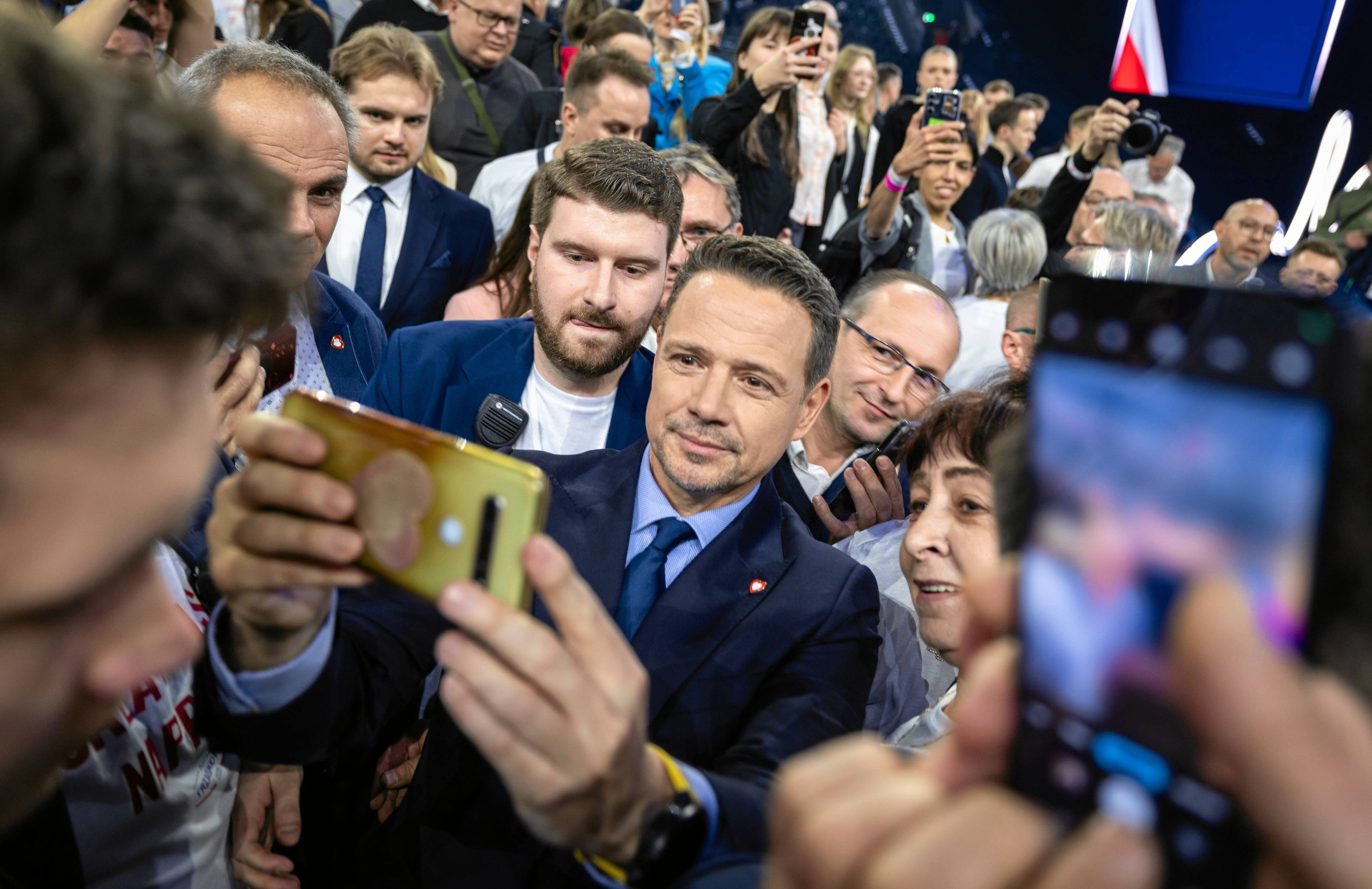 Tłum ludzi, w środku mężczyzna robiący sobie selfi z uiczestnikami wiecu