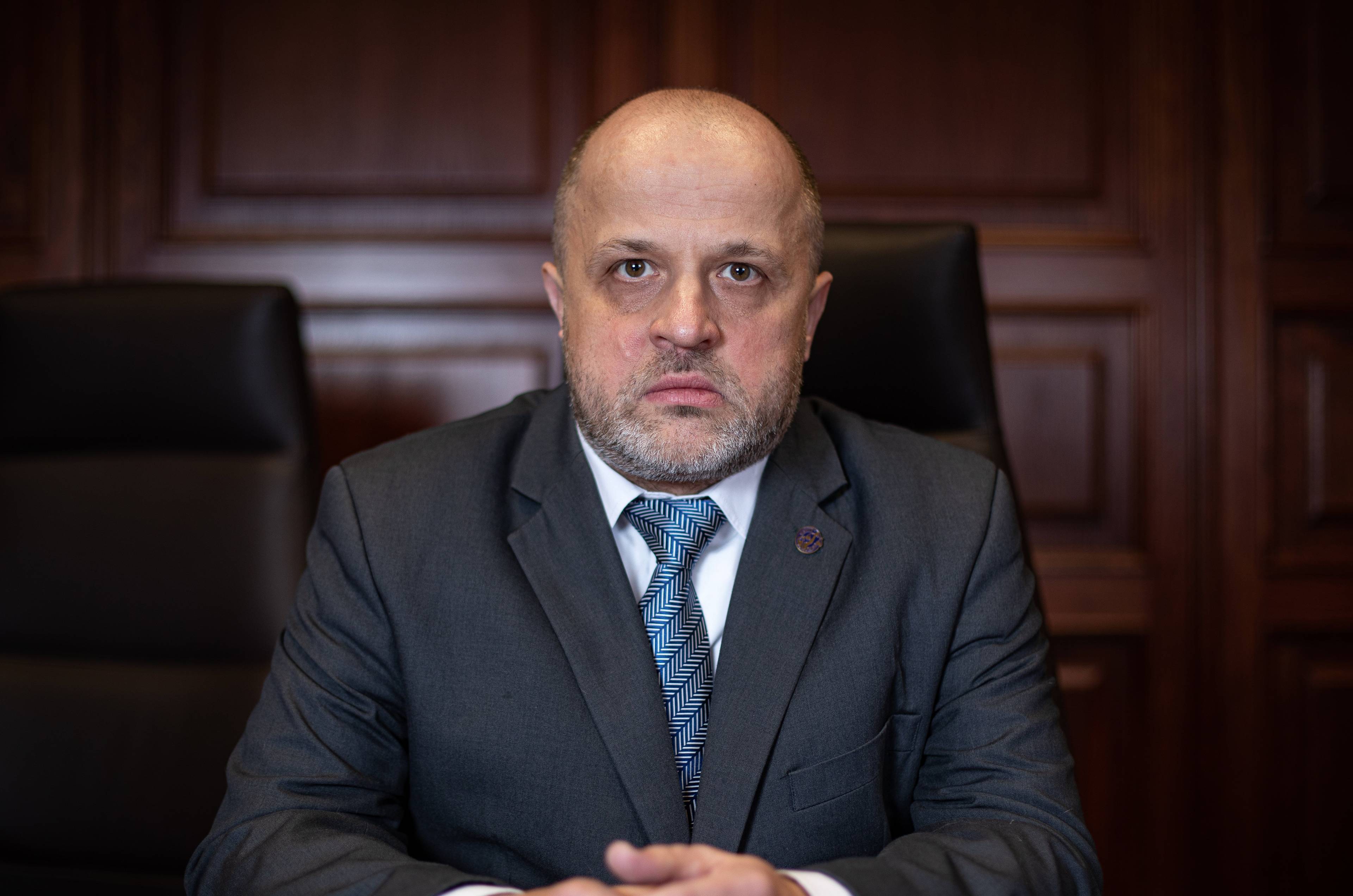 Piotr Gąciarek: mężczyzna w ciemnym garniturze i niebieskim krawacie