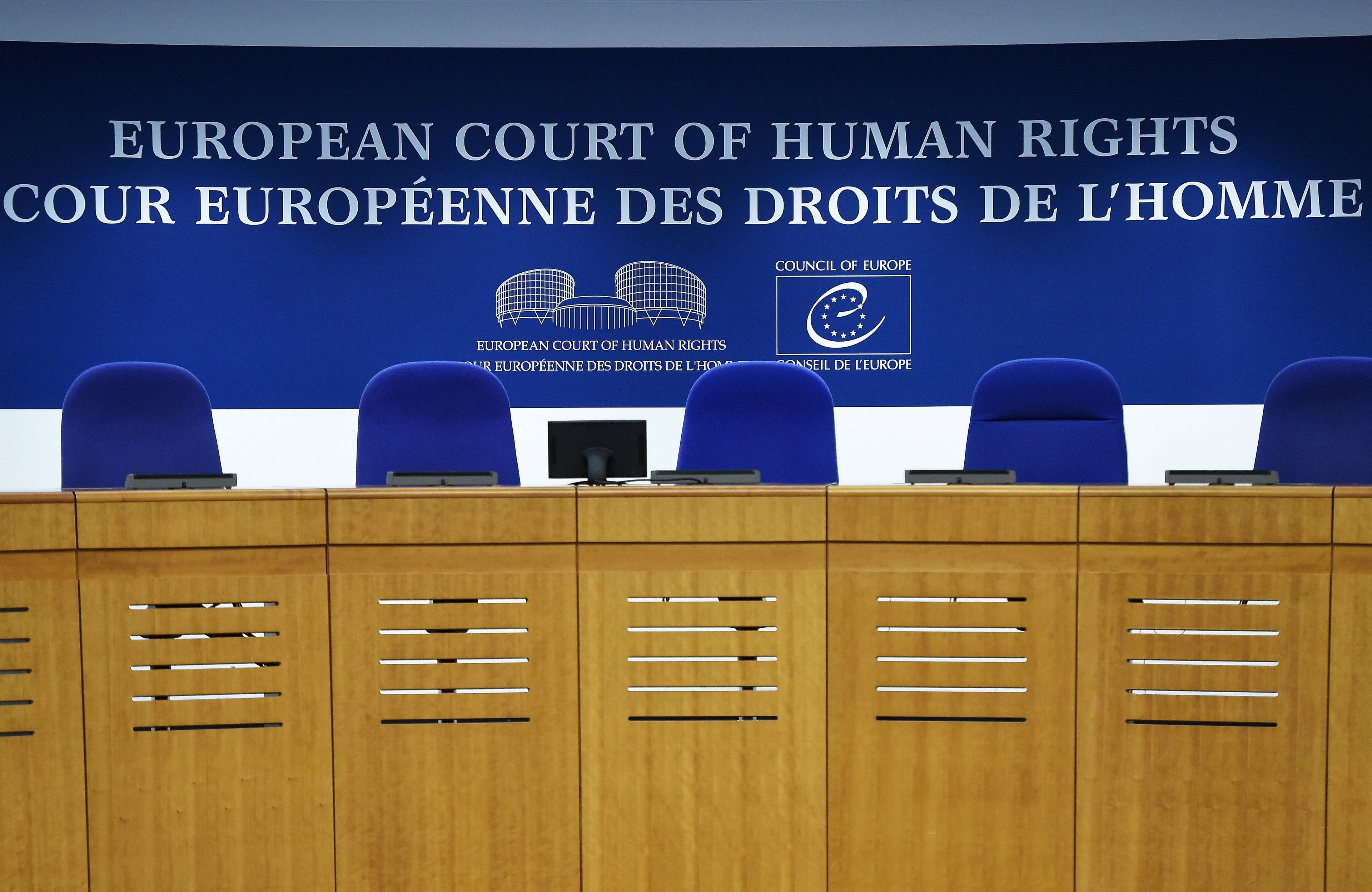 Miescja dla sędziów za stołem trynunału. Na górze angielski i francuskie napis: Europejski Trybunał Praw Człowieka