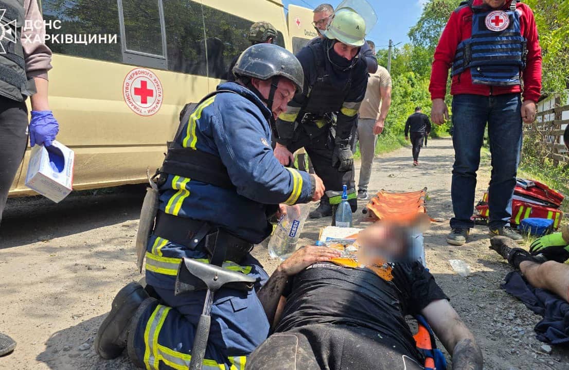 Na zdjęciu widać sześć osób. Cztery z nich, to są ratownicy, którzy udzielają pomocy medycznej cywilom.