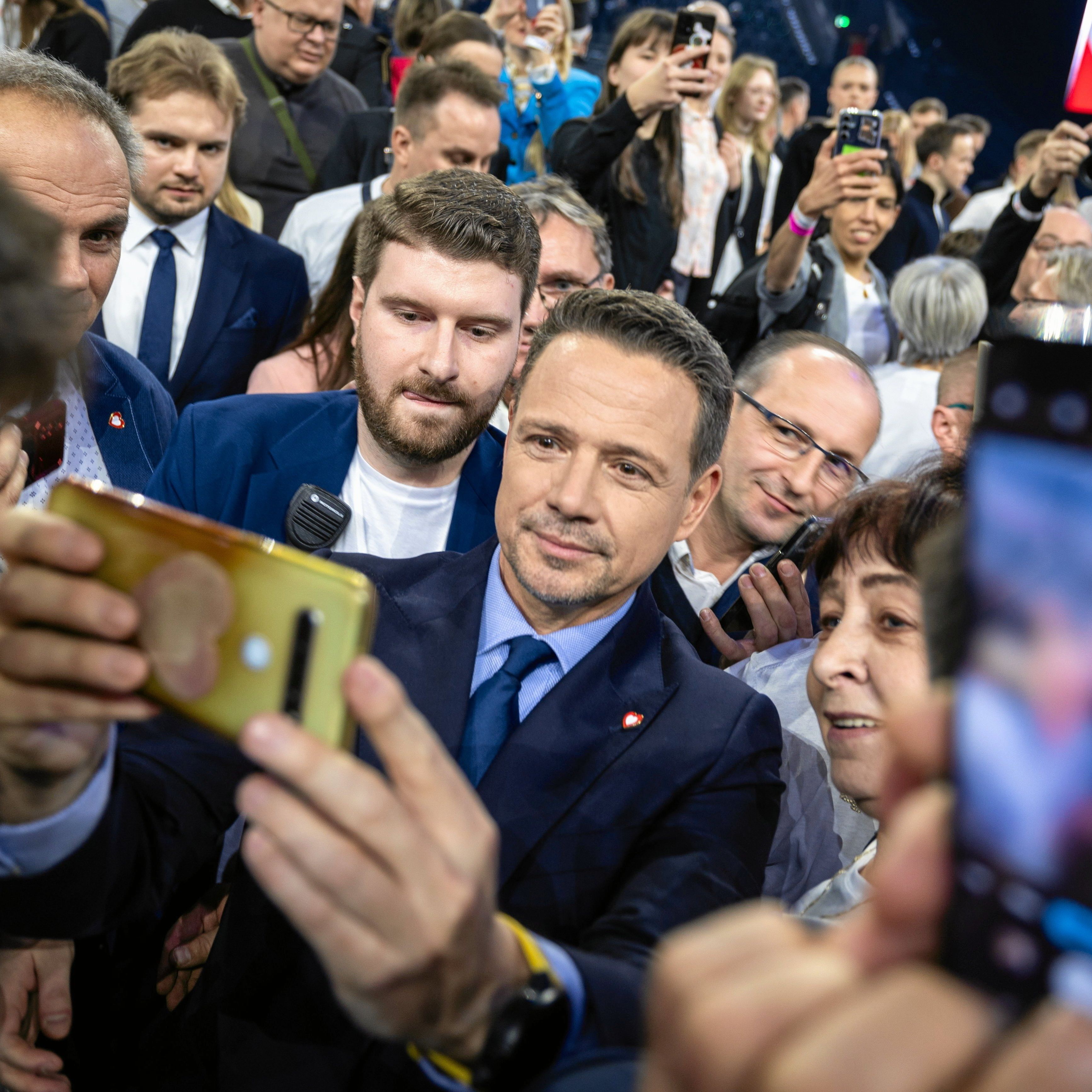 Tłum ludzi, w środku mężczyzna robiący sobie selfi z uiczestnikami wiecu