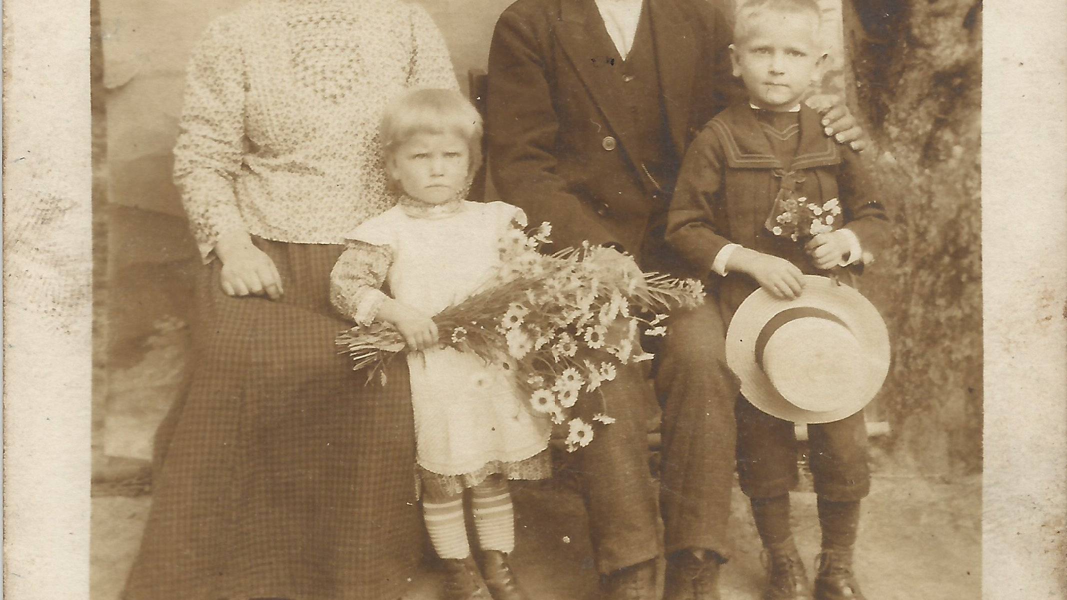 chłopska rodzina z lat 20. XX wieku z dwójką dzieci pozuje w odświętnych strojach