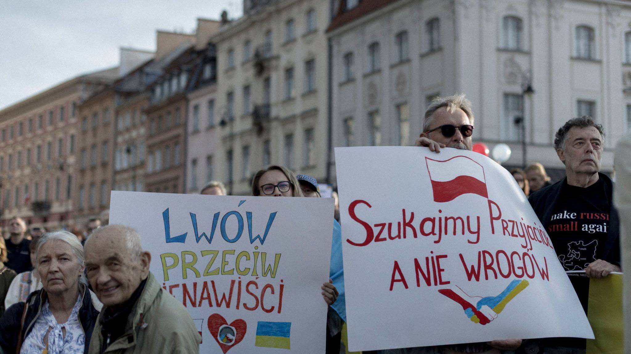 Na zdjęciu jest kilka osob, trzymają w rękach plakaty