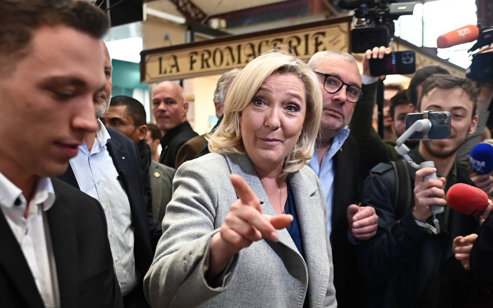 French far-right party Rassemblement National (RN) presidential candidate Marine Le Pen (C)gestures during a campaign trip in Narbonne, southern France, on April 8, 2022, two days before the French presidential election's first round. (Photo by Lionel BONAVENTURE / AFP)