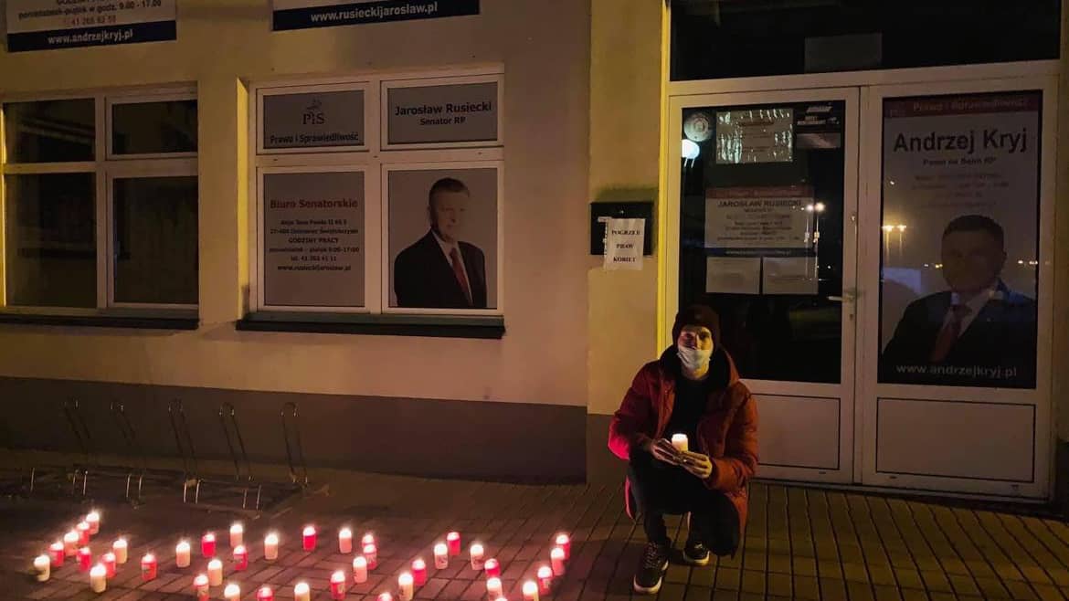 Świeczki ułozone w napis WON przed budynkiem z napisem PIS