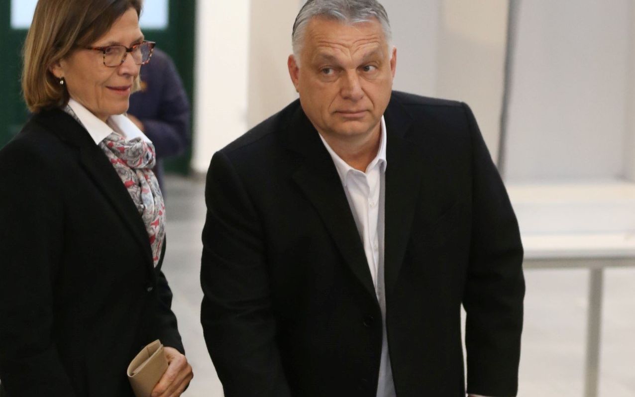 Hungarian Prime Minister Viktor Orban (R) casts his ballot as his wife Aniko Levai looks on at a polling station in Budapest, Hungary, during general elections on April 3, 2022. - Long-time nationalist Hungarian Prime Minister Viktor Orban faces a united opposition for the first time as he goes head-to-head in general elections against conservative politician Peter Marki-Zay. (Photo by FERENC ISZA / AFP)