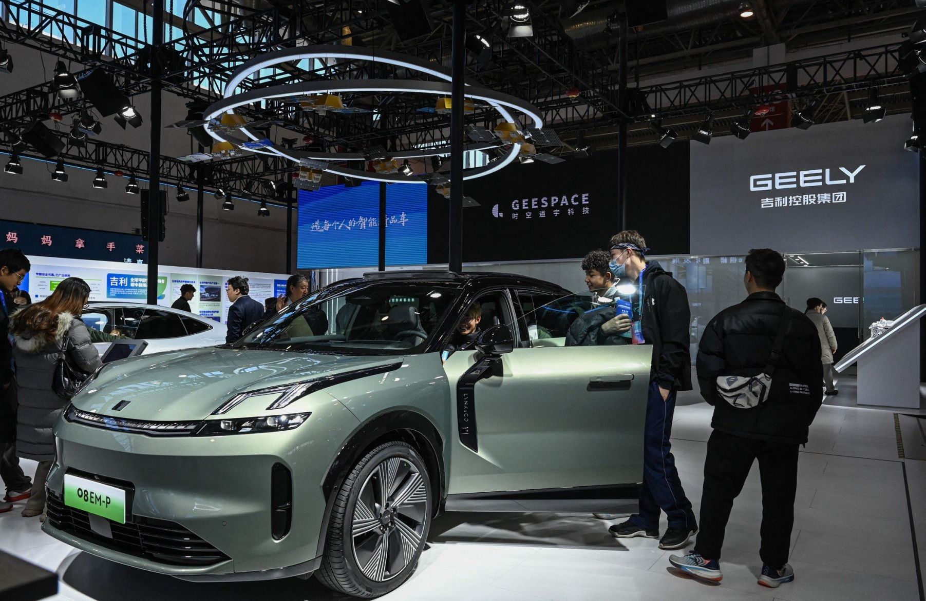 Ludzie oglądają nowy samochód elektryczny firmy Geely podczas targów w Pekinie, 1.12.2023 r.