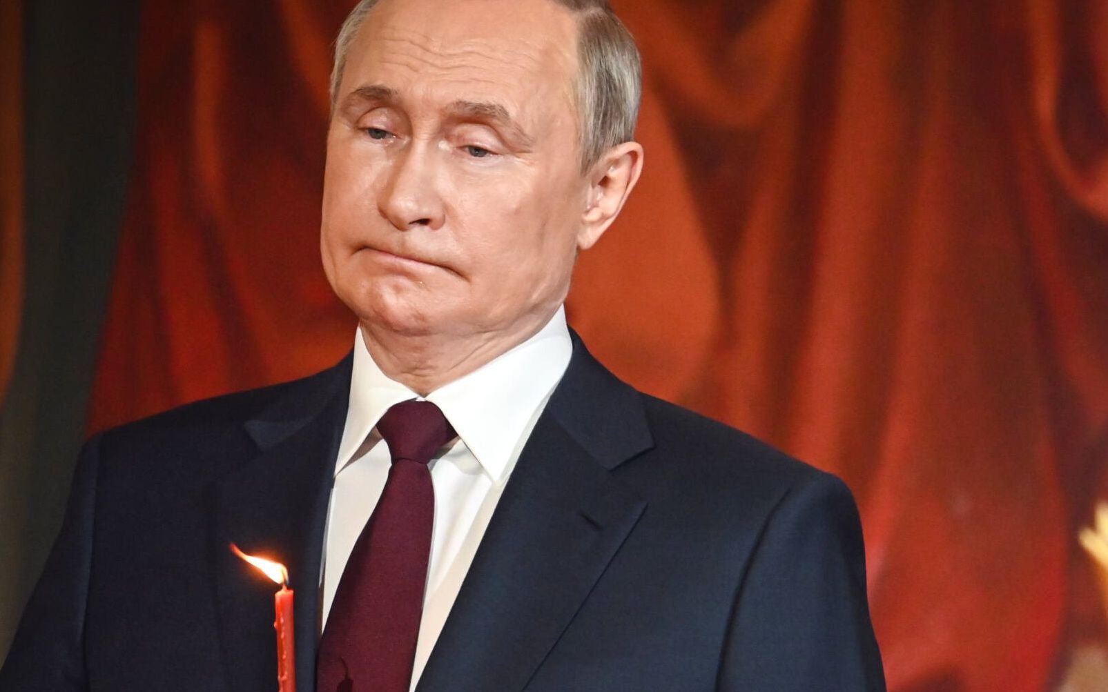 Russian President Vladimir Putin holds a candle during an Orthodox Easter service, late on April 23, 2022 in Moscow. (Photo by Alexander NEMENOV / AFP)